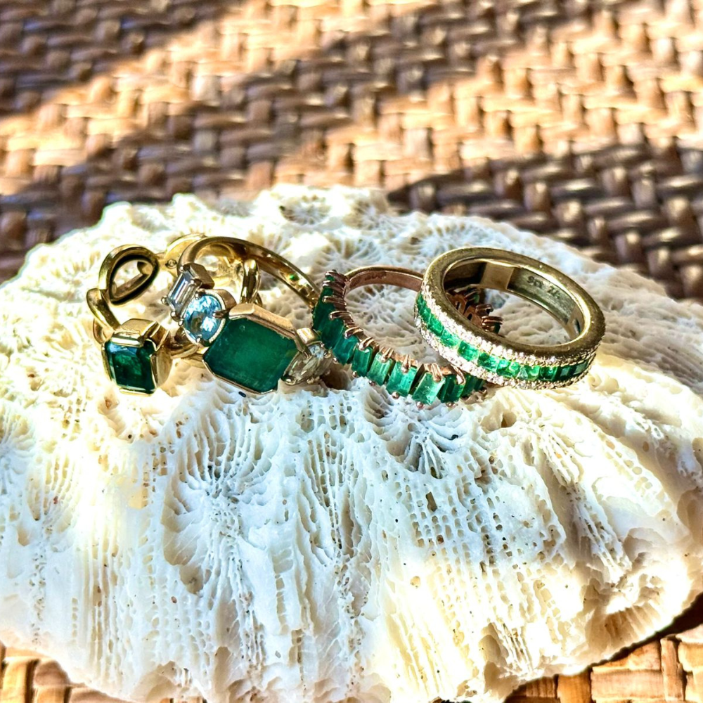 Square emeralds set with diamonds on either side, all in 9ct yellow gold.